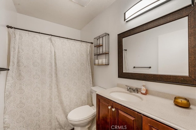 bathroom featuring curtained shower, vanity, and toilet