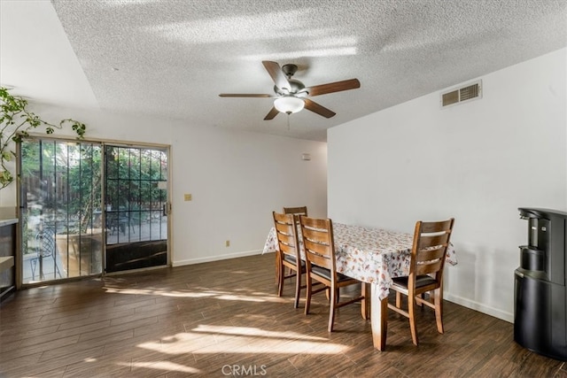 dining area with ceiling fan, a textured ceiling, and dark wood-type flooring