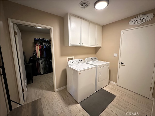 laundry room with cabinets, light hardwood / wood-style flooring, and independent washer and dryer