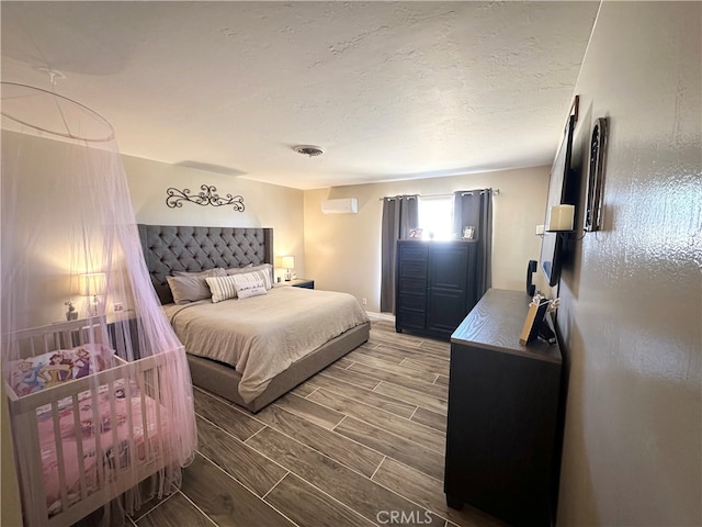 bedroom featuring wood-type flooring and a wall unit AC