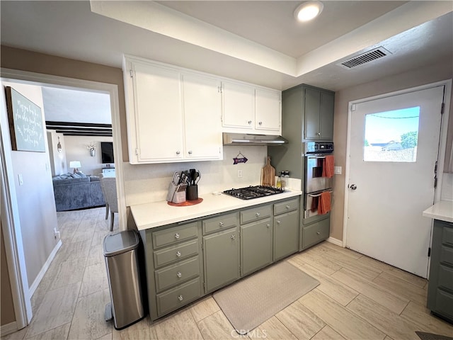 kitchen with light hardwood / wood-style flooring, white cabinetry, stainless steel gas cooktop, and a healthy amount of sunlight