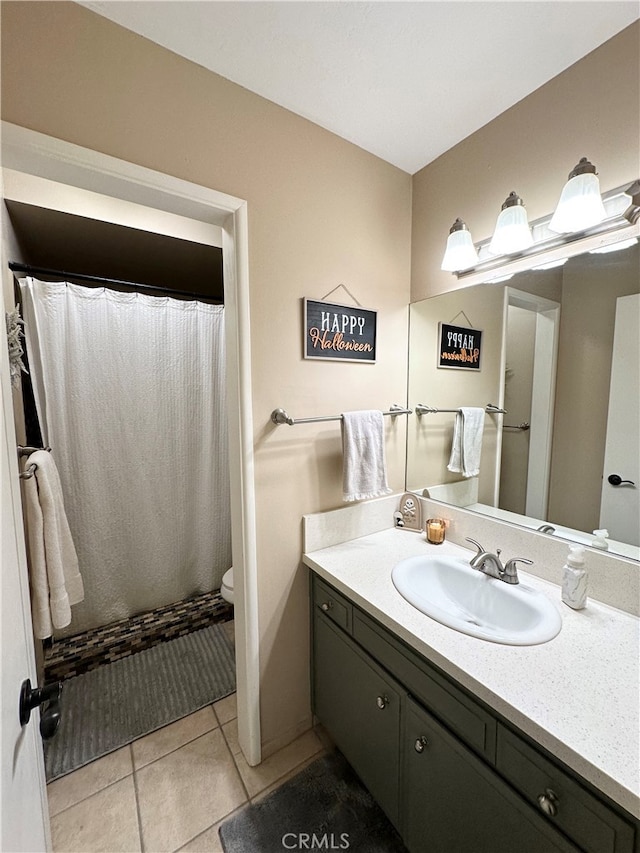 bathroom featuring tile patterned flooring, curtained shower, vanity, and toilet