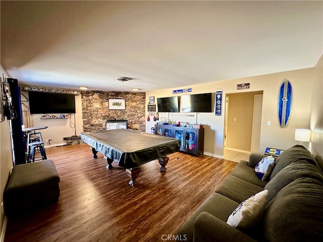 playroom featuring pool table, wood-type flooring, and a stone fireplace