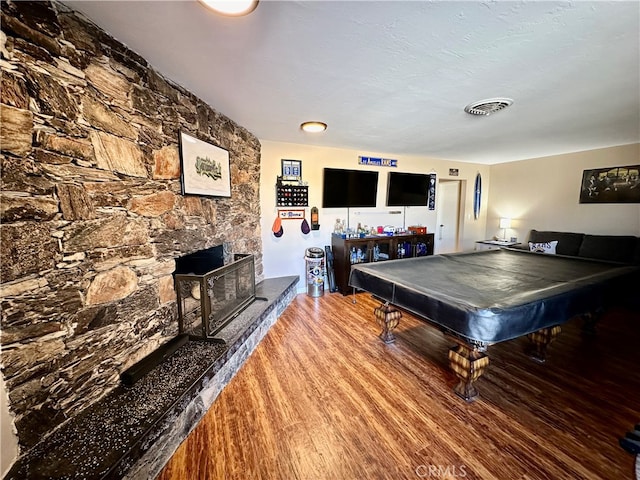 rec room featuring pool table, a fireplace, and hardwood / wood-style floors