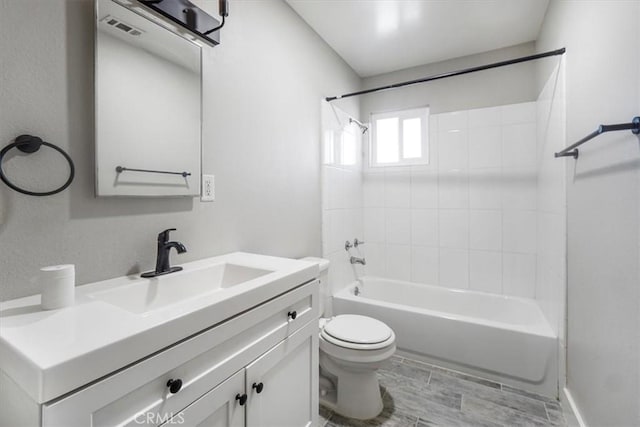 full bathroom featuring toilet, vanity, and tiled shower / bath