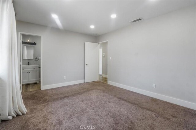 unfurnished bedroom with carpet and connected bathroom