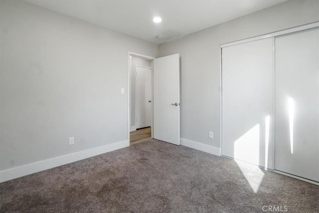 unfurnished bedroom featuring carpet floors and a closet