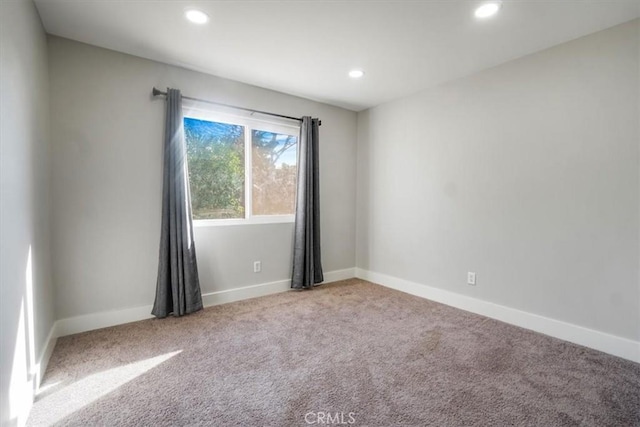 spare room featuring light colored carpet