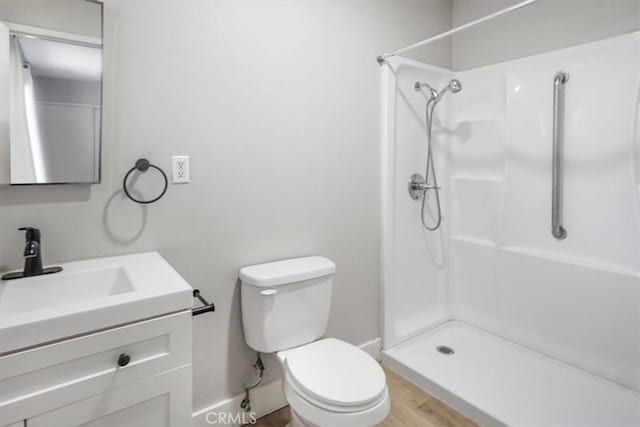 bathroom featuring a shower, toilet, and vanity