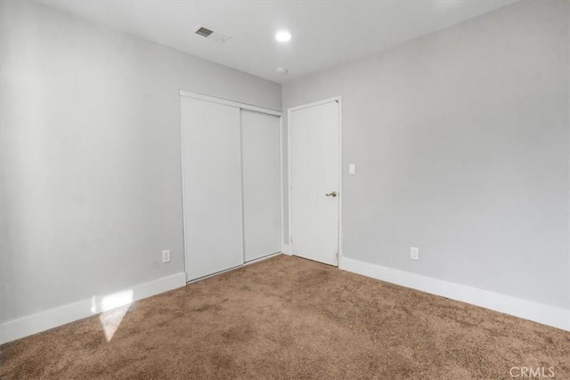 unfurnished bedroom with a closet and carpet