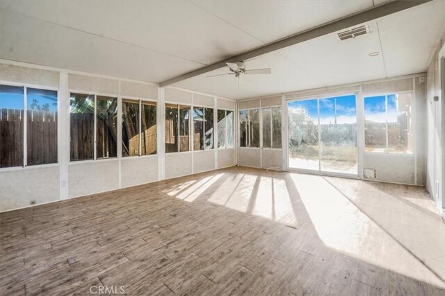 unfurnished sunroom with ceiling fan and beam ceiling