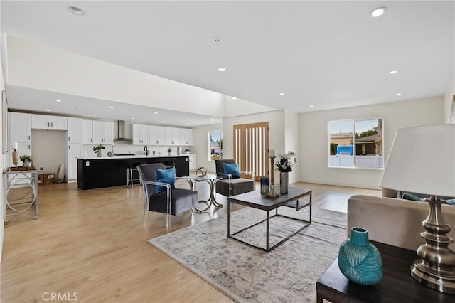 living room with light hardwood / wood-style flooring and sink