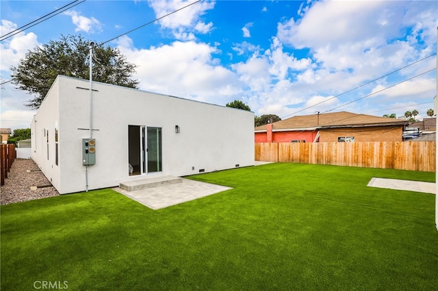 rear view of property with a yard and a patio area