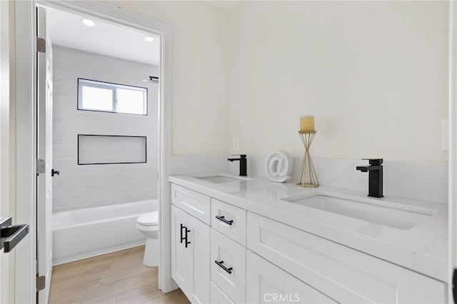 full bathroom with wood-type flooring, vanity, toilet, and shower / washtub combination