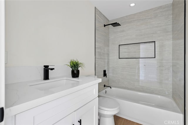 full bathroom with tiled shower / bath combo, vanity, toilet, and wood-type flooring