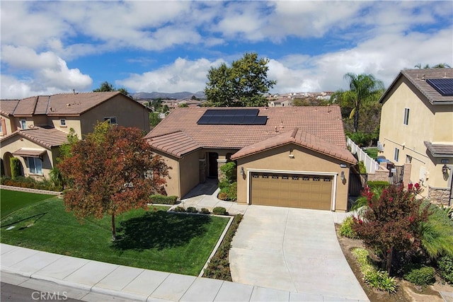 view of front facade with a garage, solar panels, and a front yard