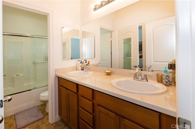 full bathroom with bath / shower combo with glass door, vanity, and toilet