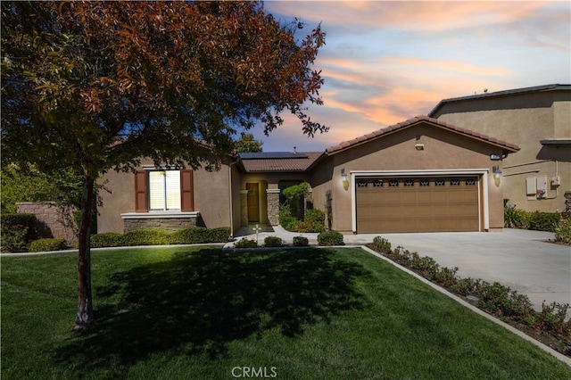 view of front of property with a garage and a yard