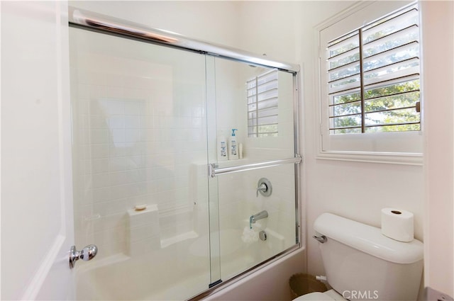 bathroom with shower / bath combination with glass door and toilet