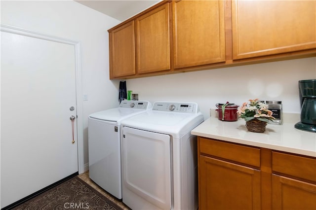 laundry area with washing machine and clothes dryer and cabinets