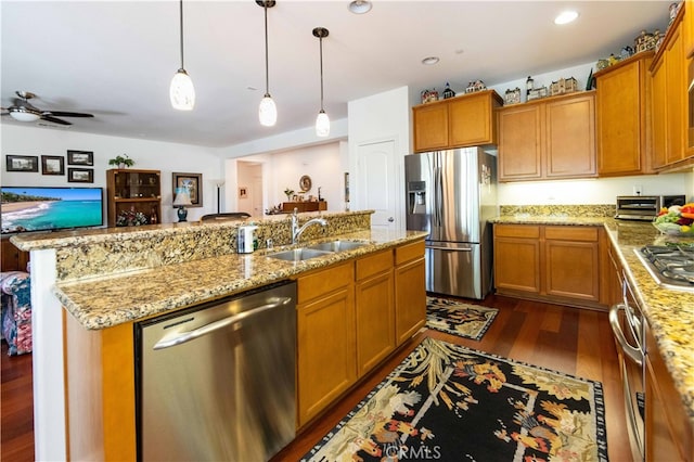 kitchen with ceiling fan, hanging light fixtures, sink, dark wood-type flooring, and stainless steel appliances