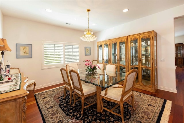 dining space featuring dark hardwood / wood-style floors and a chandelier