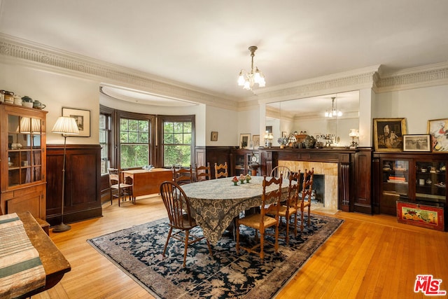 dining area featuring an inviting chandelier, light hardwood / wood-style flooring, and crown molding