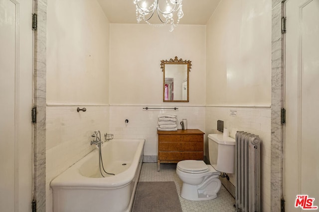 bathroom with tile walls, a bathing tub, radiator heating unit, toilet, and a notable chandelier