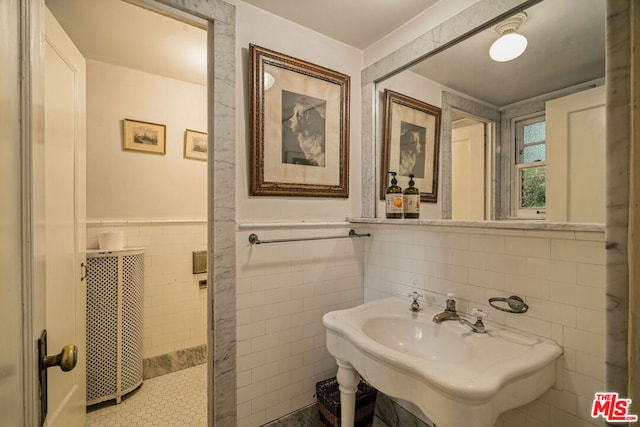 bathroom featuring tile walls and sink