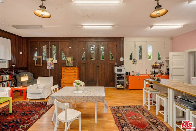 living room with light hardwood / wood-style floors and wood walls