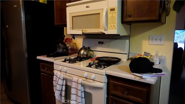 kitchen with white appliances and dark brown cabinets