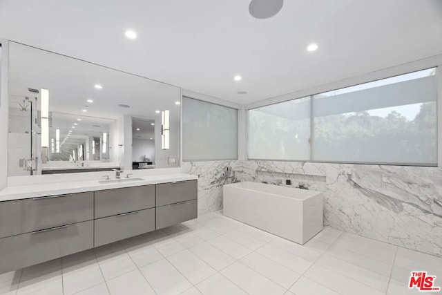 bathroom featuring plus walk in shower, tile walls, tile patterned flooring, and vanity