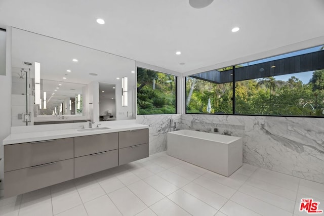 bathroom featuring independent shower and bath, tile walls, vanity, and tile patterned floors