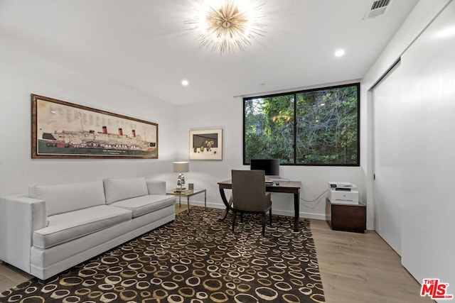 office space with light wood-type flooring and an inviting chandelier