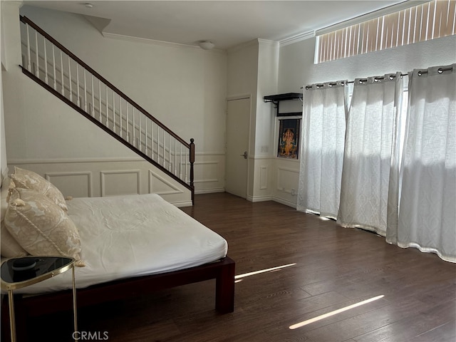 bedroom with dark hardwood / wood-style floors and ornamental molding