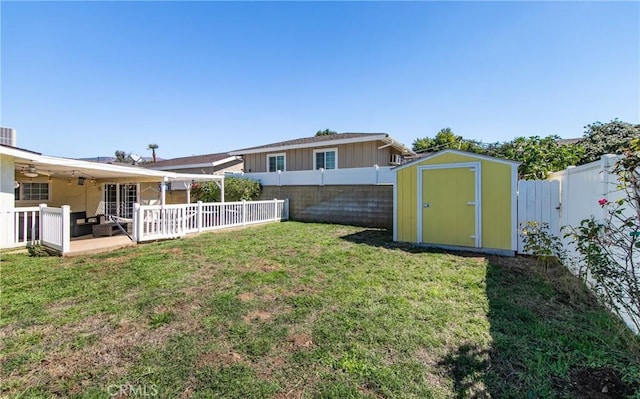 view of yard with ceiling fan and a storage shed