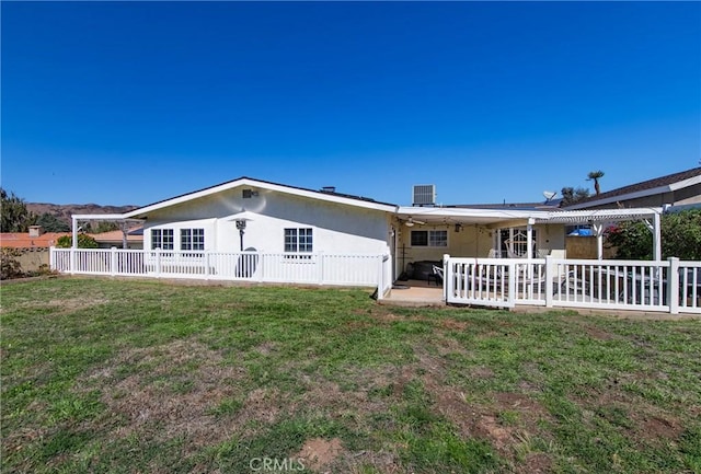 back of property featuring a yard and ceiling fan