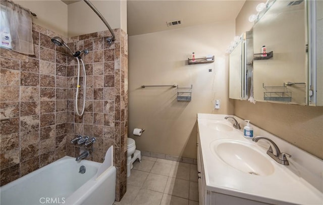 bathroom with tile patterned flooring, vanity, and tiled shower / bath