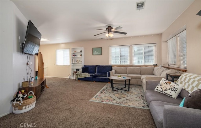 living room featuring carpet floors, ceiling fan, and a healthy amount of sunlight