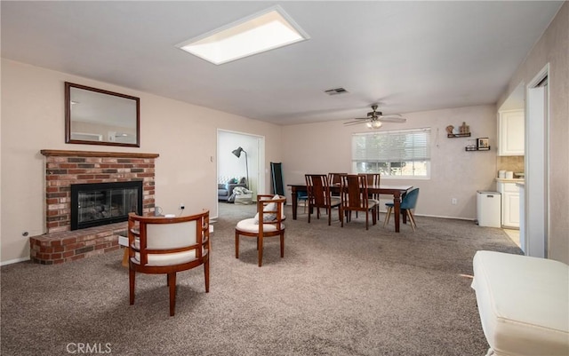 living room with carpet flooring, ceiling fan, and a brick fireplace