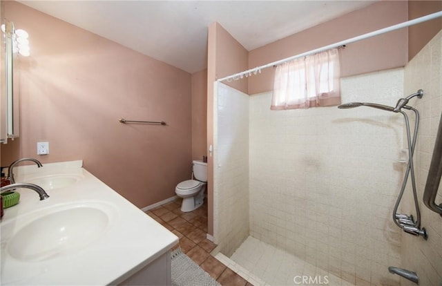 bathroom featuring tiled shower, tile patterned floors, vanity, and toilet