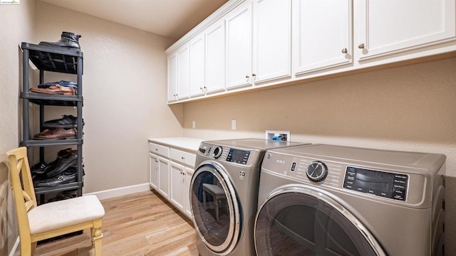 laundry area featuring cabinets, light hardwood / wood-style flooring, and independent washer and dryer