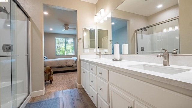 bathroom with a shower with door, vanity, hardwood / wood-style flooring, and ceiling fan