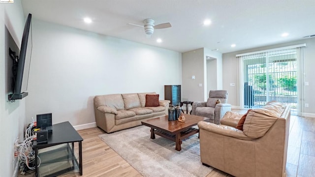 living room featuring ceiling fan and light hardwood / wood-style flooring