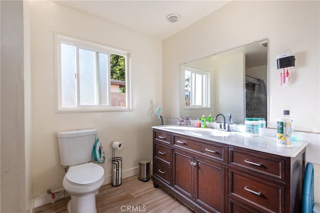 bathroom with toilet, hardwood / wood-style floors, and vanity