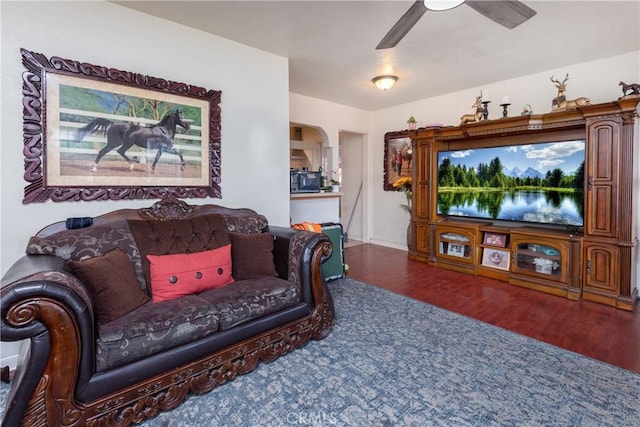 living room with ceiling fan and dark hardwood / wood-style floors