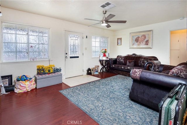 living room with ceiling fan and dark wood-type flooring