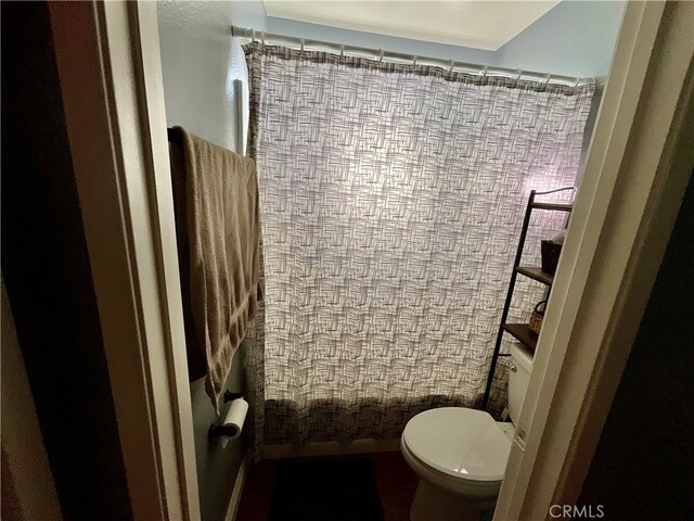 bathroom featuring toilet and a shower with shower curtain