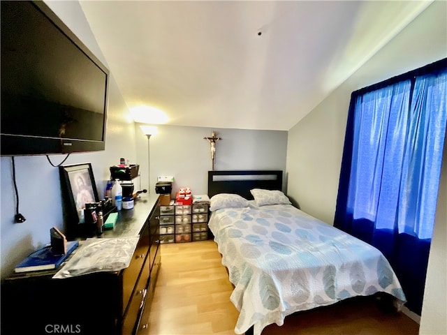 bedroom featuring light hardwood / wood-style flooring and vaulted ceiling