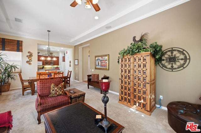 living room featuring ornamental molding, ceiling fan, and light colored carpet